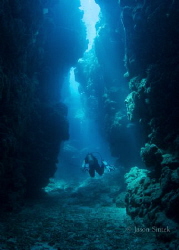 Diver navigating a passage between the reefs by Jason Sintek 